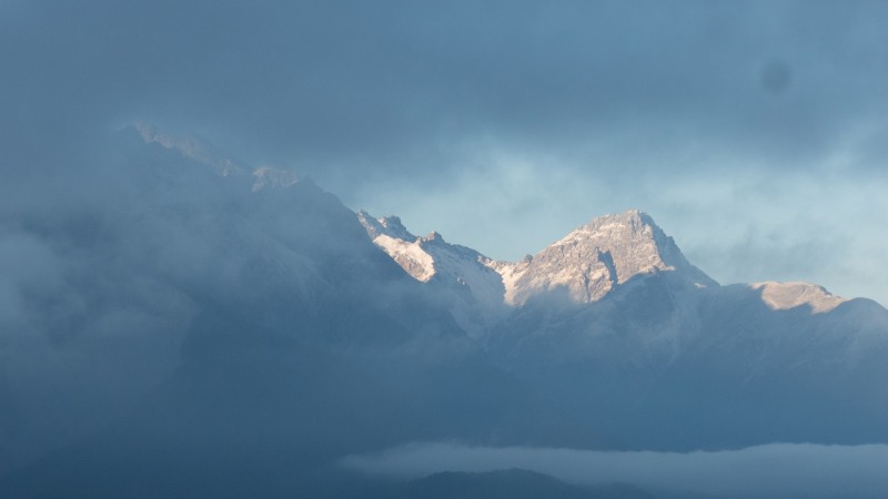 Vista dalla finestra con picci nevicati e nuvolati